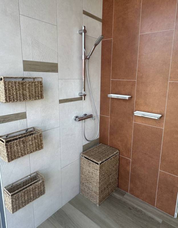 Exposition d'une douche contemporaine avec une robinetterie chromé et des paniers tressés à Libourne à côté d'Izon