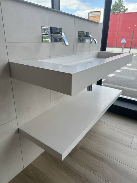 Plan vasque suspendu sur mesure en solid surface minimaliste et mitigeur murale encastré dans notre showroom à Libourne près de Coutras