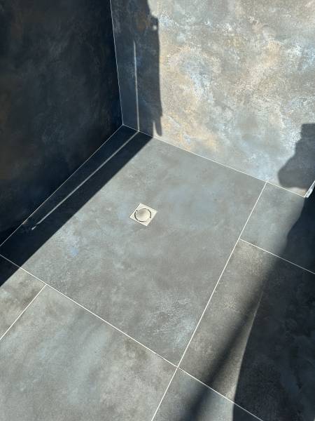 Exposition d'une douche ayant une robinetterie noir mat et d'un receveur chez Carrelage et Bain de A à Z à Libourne proche de Cameyrac