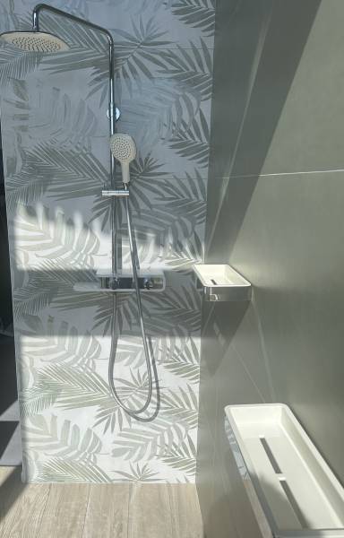 Exposition d'une douche avec une robinetterie chromée et des tablettes murale à Libourne à côté de Coutras