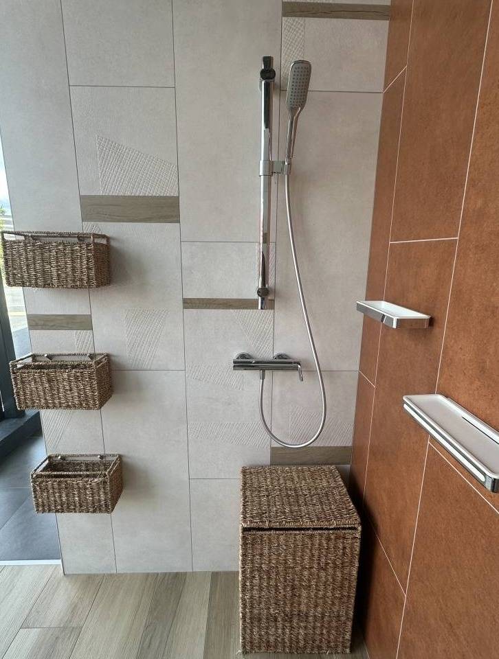 Exposition d'une douche contemporaine avec une robinetterie chromé et des paniers tressés à Libourne à côté d'Izon