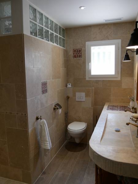 Salle de bain en travertin et carrelage imitation bois à Saint denis de pile proche Libourne.